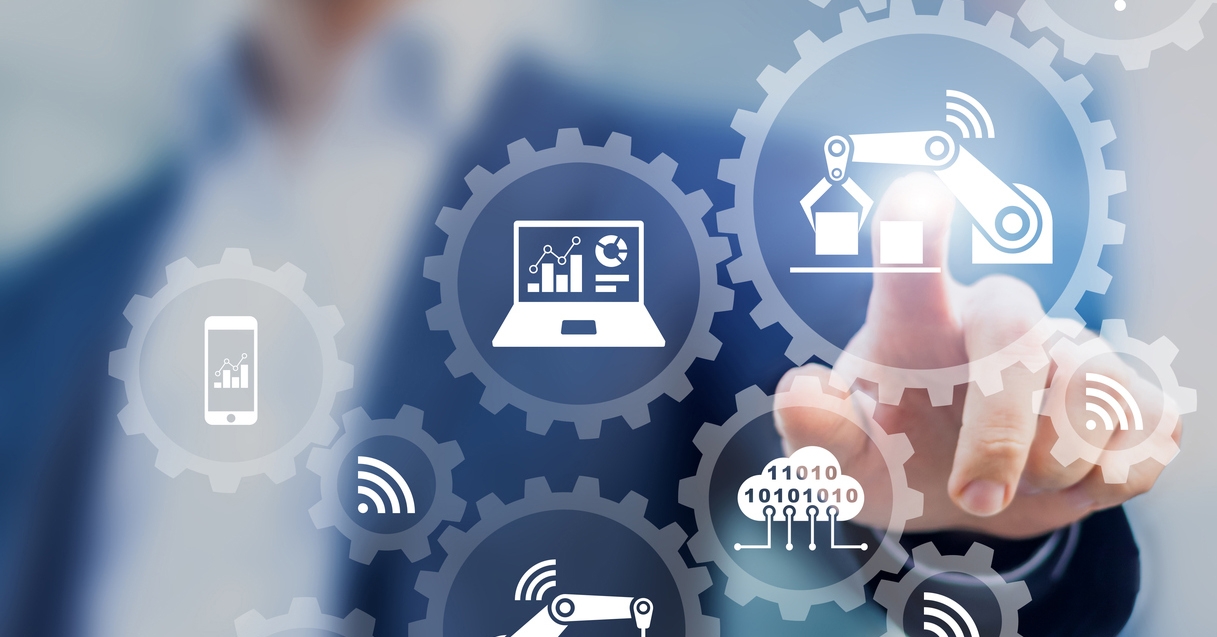 Um mão está teclando uma tela através da tecnologia touch, na tela aparecem diferentes ícones relativos à tecnologia, como o símbolo de wifi, um computador com engrenagens, uma máquina e etc. O conjunto dessas tecnologias fazem parte da proposta de uma indústria 4.0